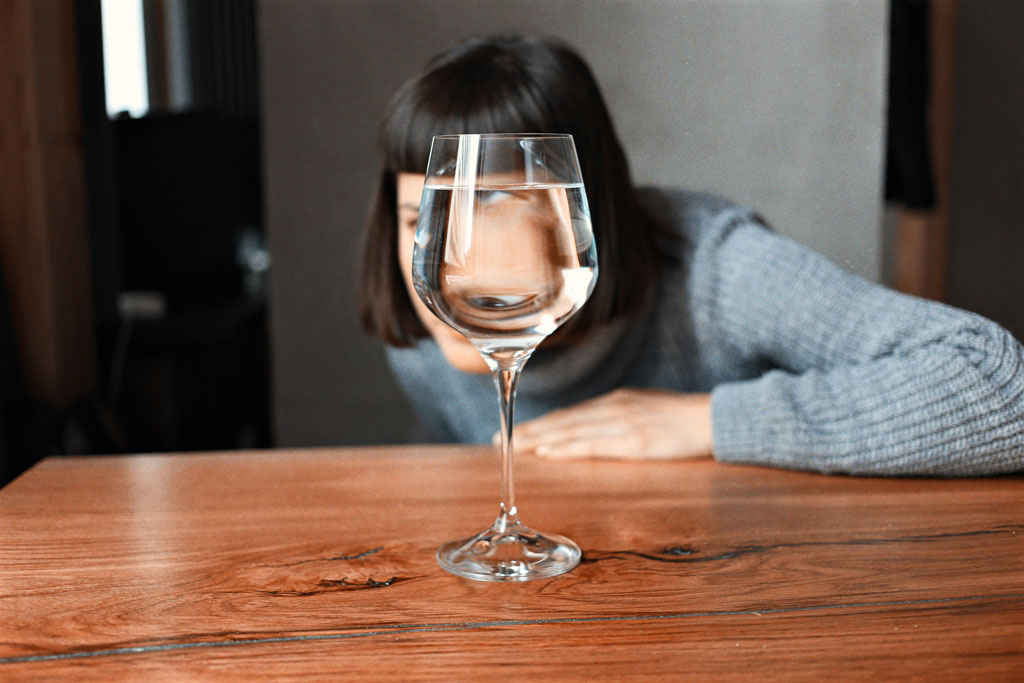 Woman looking through glass of water