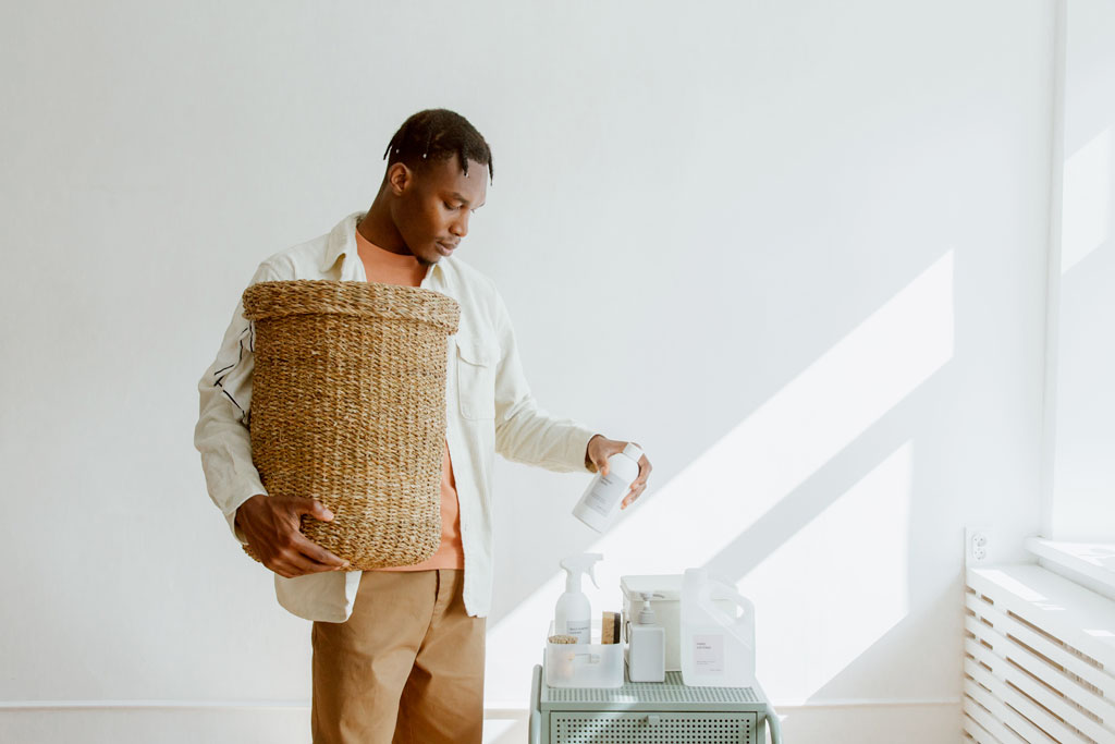 Man holding a laundry basket choosing a detergent