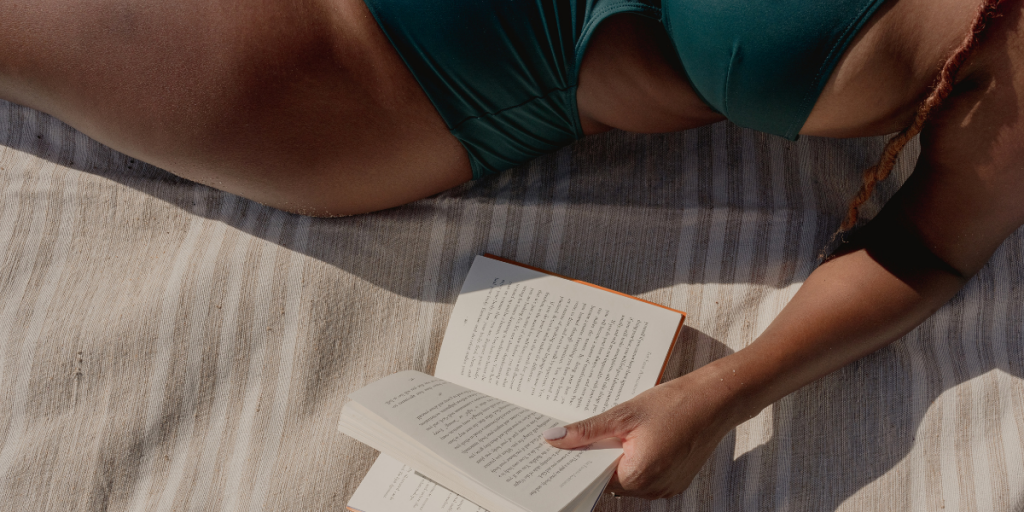 The woman Is reading and sunbathing